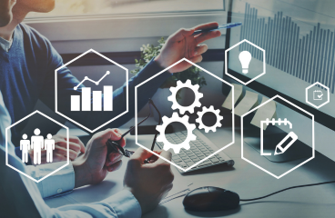 Duas pessoas analisando gráficos em um laptop, com ícones de engrenagens, gráficos e ideias sobrepostos.